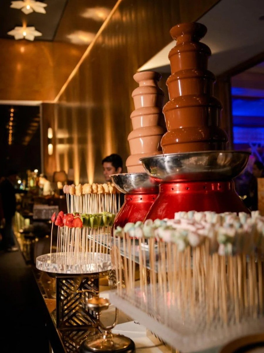 Double chocolate fountain dessert station with fruit skewers at a wedding or gala — Abhijat Catering