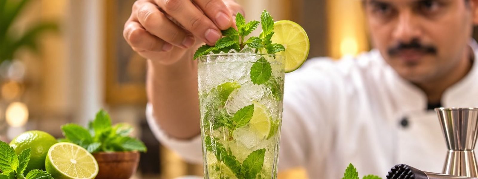 Chef garnishing a fresh mojito with mint — attention to detail at Abhijat Catering